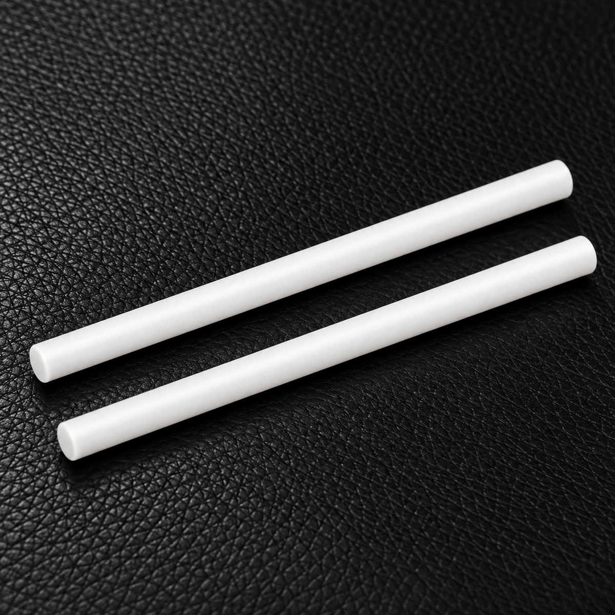 Two slim white Roadrunner diffuser refill sticks displayed on black leather